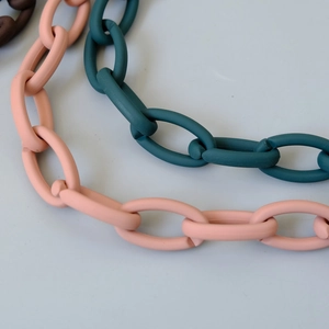 Detail of matte resin link chains in pink, dark green, and brown colors for handbags