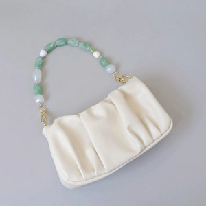 Detail of cream pleated PU leather bag with green and white resin beaded handle