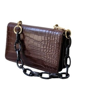 Dark brown crocodile pattern handbag with stylish black and white resin chain handle