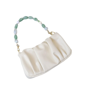 Chic cream ruched shoulder bag featuring a stylish green and white beaded handle