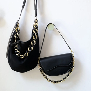 Detailansicht schwarzer Taschen mit kontrastierenden Acrylharzketten in Schwarz und Gold