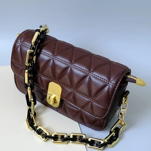Nahaufnahme braune Steppledertasche mit goldener Schließe und gemischter Harzkette