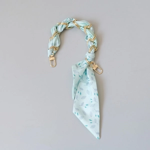 Détail de la poignée de sac en foulard de soie bleu clair tissée avec une chaîne dorée