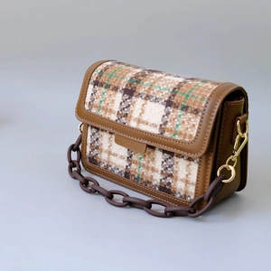 Detail of vintage plaid wool handbag with resin chain and premium leather trim