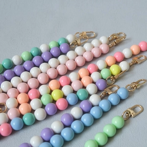Macro detail of colorful beaded straps with golden lobster clasps for bags and phones