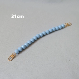 Detail showing a 31cm light blue resin bead strap with gold lobster claw clasps