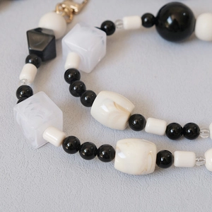 Cadena de cuentas artesanal en blanco y negro con cierre dorado para bolsos y móviles