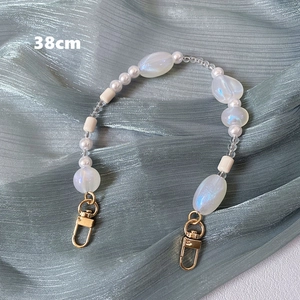 Detail of 38cm handmade colorful beaded strap with golden lobster clasps on silk fabric