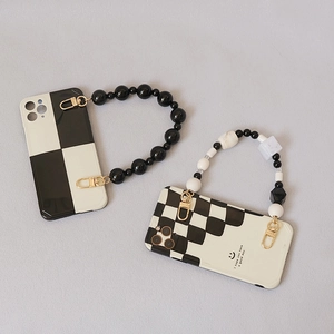 Detalle de funda de móvil de tablero con correa de cuentas vintage y diseño de sonrisa