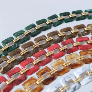 Close-up of colorful resin acrylic chain links with gold metal rings for handbag straps