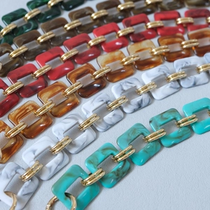 Close-up of vintage resin links with golden metal rings for handbags accessories
