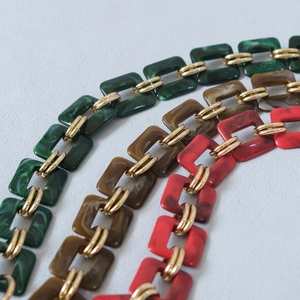 Detailed macro view of vintage resin chain links with gold metal connectors for bags