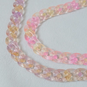 Gros plan d'une chaîne en résine acrylique dégradée pastel en rose, violet et jaune