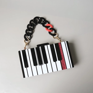 Vue détaillée du sac de soirée piano avec rayures noires blanches et accent rouge