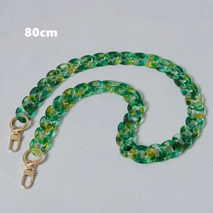 Macro detail of 80cm green and yellow marble acrylic fishbone chain with gold lobster clasps
