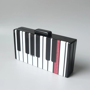 Pochette élégante en acrylique avec motif clavier de piano et détails pailletés rouges
