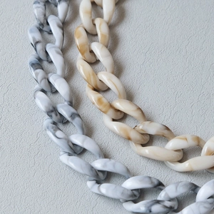 Detailed macro view of acrylic chain links with grey and amber marble textures