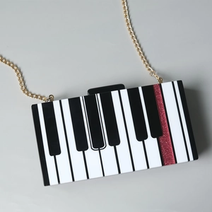 Pochette élégante en acrylique motif touches de piano avec bande rouge et chaîne dorée