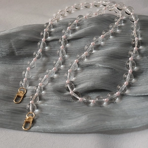 Detail showing acrylic clear beads and pink pearls on a multi-functional chain with gold clasp