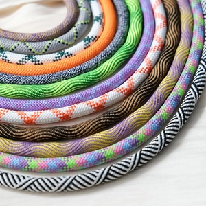 Macro view of colorful braided crossbody phone straps showing detailed woven textures