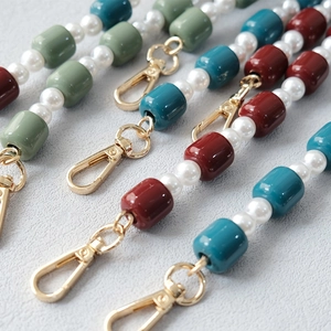 Detail of colorful acrylic beads and pearls with gold lobster claw clasp for bags