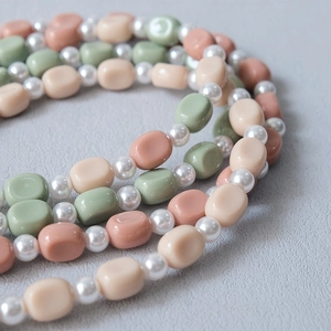 Close-up of Morandi acrylic beads and faux pearls on a stylish crossbody strap chain