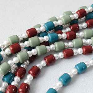 Macro detail of colorful candy-colored acrylic beads and white pearls on a stylish strap