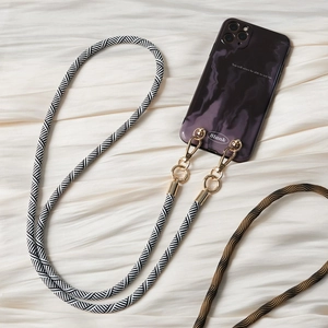 Detail of black and white woven phone strap with gold hooks on marble texture case