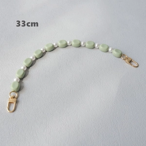 Detail of a 33cm acrylic strap with light green square beads and white pearls