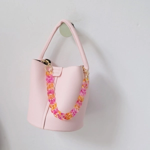 Detail of pink bucket bag with gradient acrylic chain and lychee grain leather texture