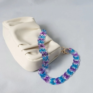 Blue-purple gradient acrylic chain strap with golden spring ring on a cream leather bag