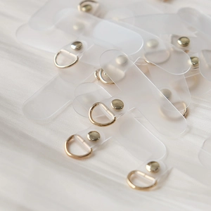 Detail view of transparent frosted TPU phone lanyard patches with gold metal D-rings