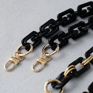 Detail of black acrylic chain links and gold lobster clasp for handbag straps
