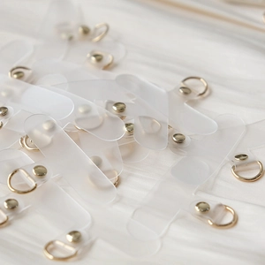 Macro detail of transparent matte phone lanyard patches with gold D-ring hardware