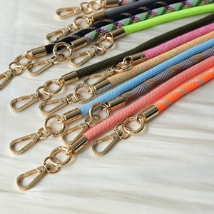 Detailed view of woven phone lanyards in multiple colors with gold metal hooks
