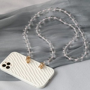 Detailed close-up of acrylic clear bead strap attached to a wave texture beige phone case