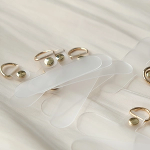 Macro shot of semi-transparent matte TPU phone lanyard pads with gold D-ring and rivets