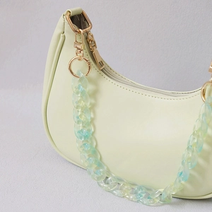 Détail du sac demi-lune vert menthe avec chaîne en résine multicolore et boucles dorées