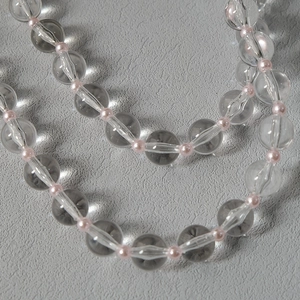 Detailed macro view of clear acrylic beads and pink faux pearls on a stylish shoulder strap