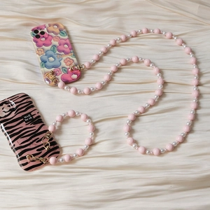 Détail de dragonnes de téléphone en perles de résine avec coques fleurie et zèbre