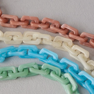 Macro shot of colorful acrylic resin chain links in pastel marble texture for bag straps