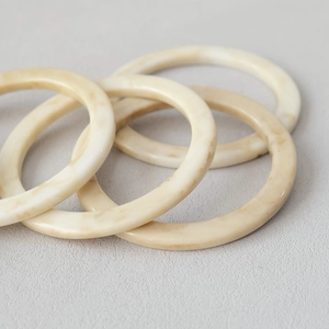 Close-up of marble-textured resin bag handles with amber and cream acrylic patterns