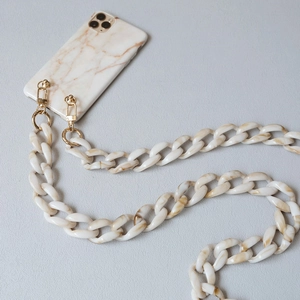 Detail of acrylic resin chain strap with gold metal clasps and marble phone case