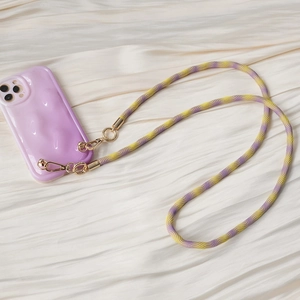 Detail of purple wave pattern phone case with yellow braided crossbody lanyard and gold hooks