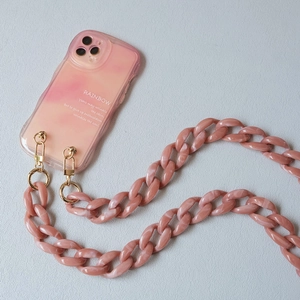 Close-up of pink acrylic chain strap with gold hooks on a marble texture phone case