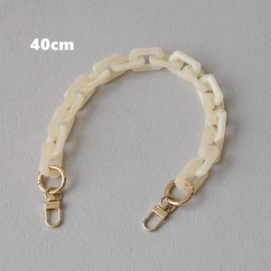 Detail view of a 40cm cream acrylic chain strap with gold metal lobster clasps