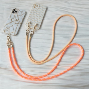 Detail of woven crossbody phone lanyards and patterned cases with gold metal clasps