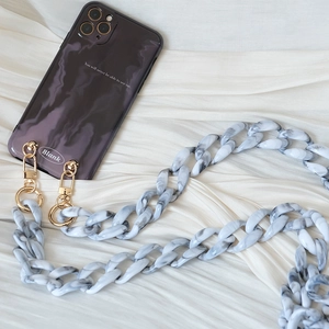 Detail of grey resin acrylic chain strap on dark marble smoke pattern phone case