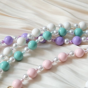 Gros plan d'une chaîne en perles acryliques colorées avec perles rose et violet