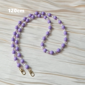 Détail de chaîne en perles acryliques violettes de 120 cm avec fermoirs dorés sur satin